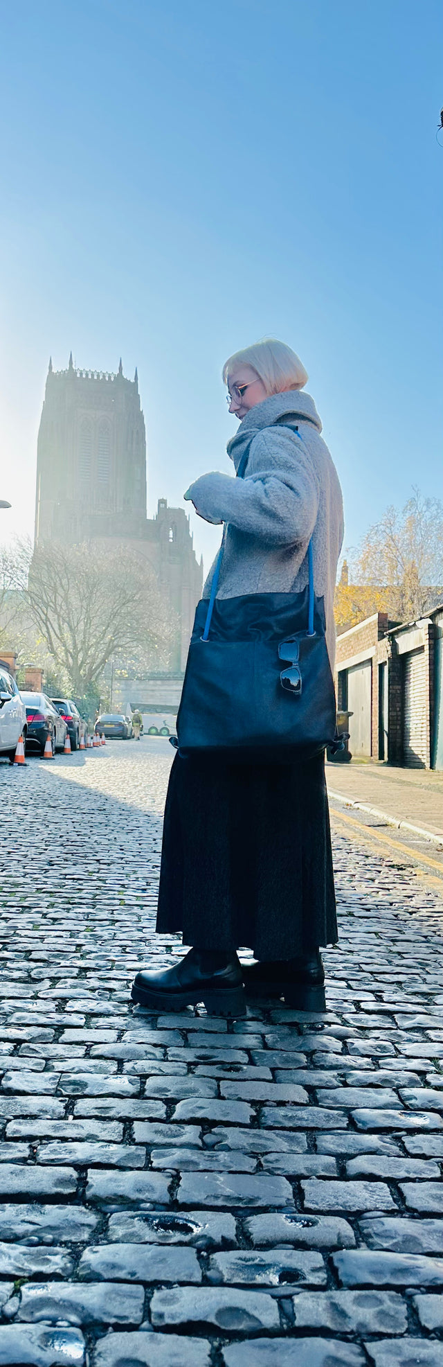 black bag modelled on cobble street with cathedral in background