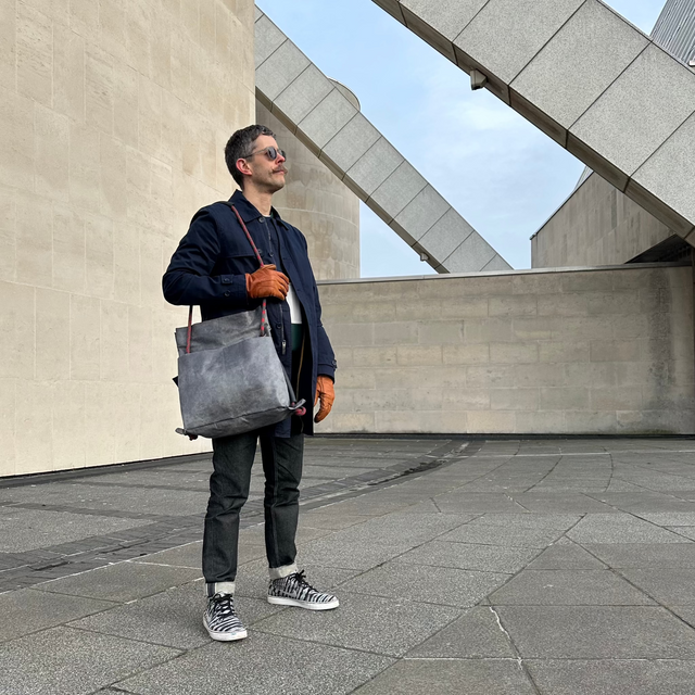 brutalist architecture backdrop to convertible commuter bag
