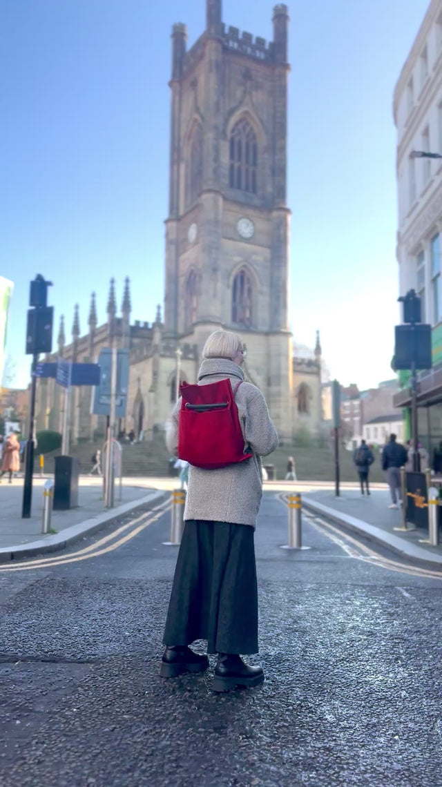 Ditto red crimson convertible bag going from back to shoulder with the Bombed Out Church in Liverpool