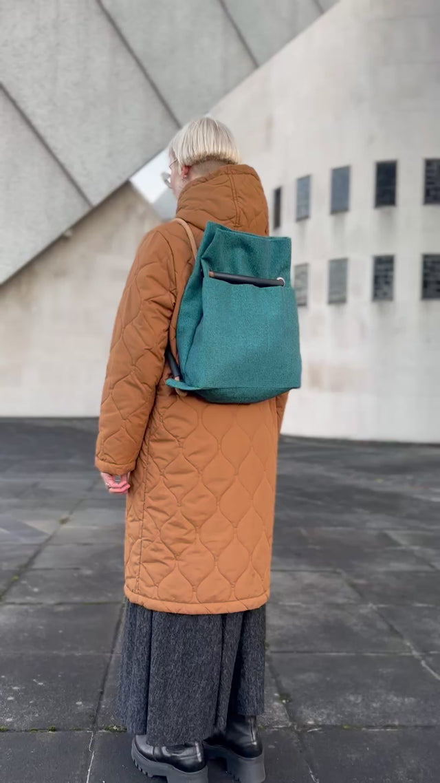 teal textile convertible bag going from back to shoulder