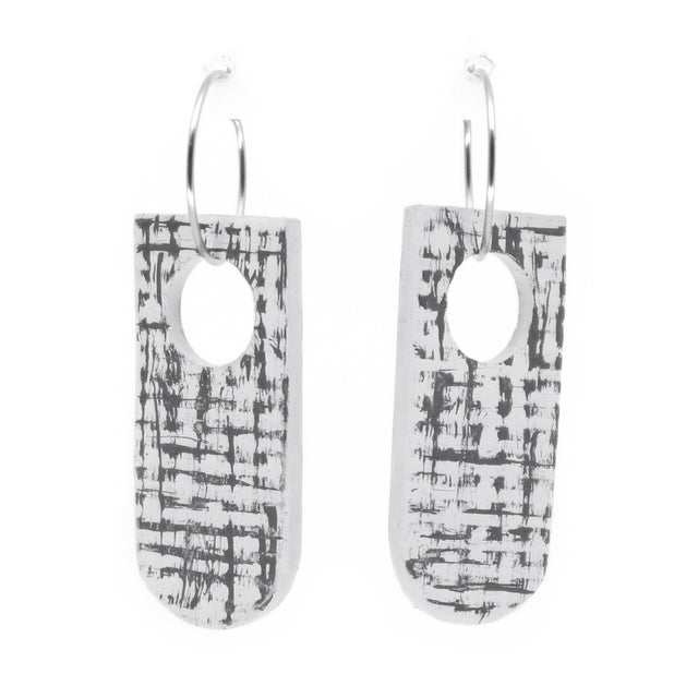 Pair of earrings with grey and white abstract design on a white background
