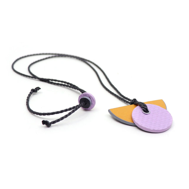 Linoleum orange & lilac Bauhaus pendant necklace on grey twisted string