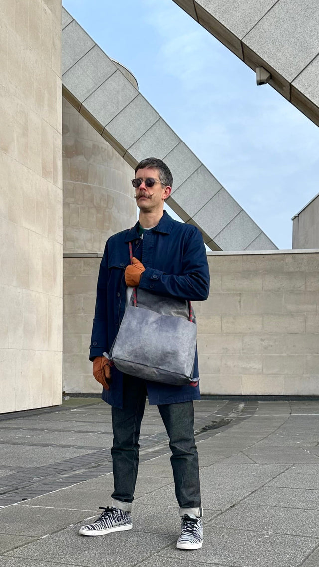 slate grey commuter bag with recycled climbing rope  with brutalist architecture