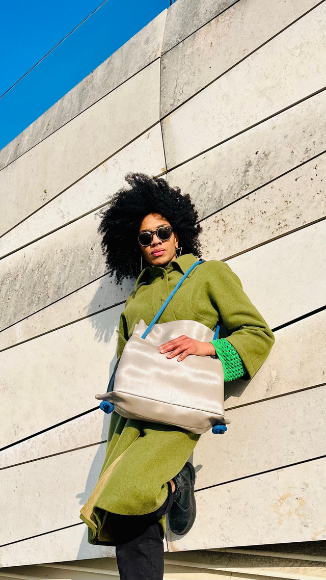 platinum shoulder convertible bag against geometric wall 