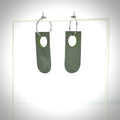 rotating grey and green earrings on an earring stand