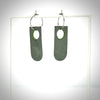 rotating grey and green earrings on an earring stand
